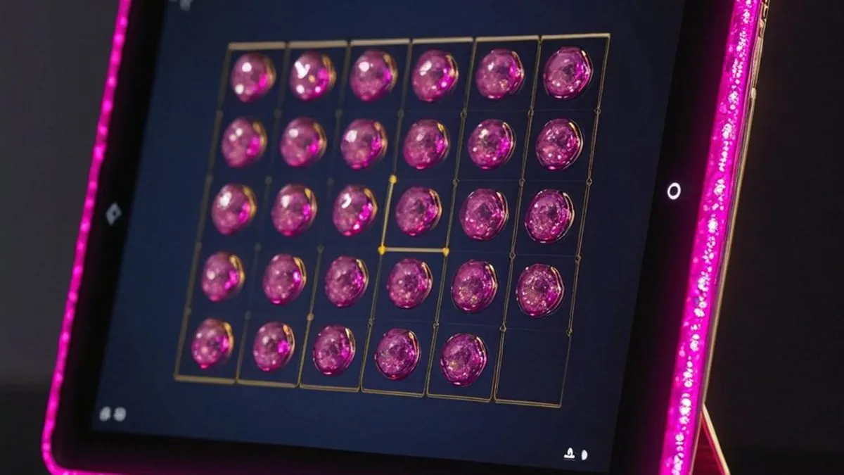 Tablet con borde rosa y una cuadrícula de gemas rosas en pantalla sobre una base dorada
